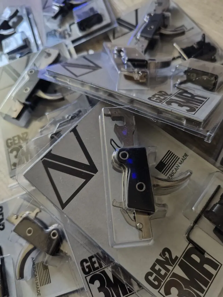 Close-up of a firearm trigger mechanism with engraved text.